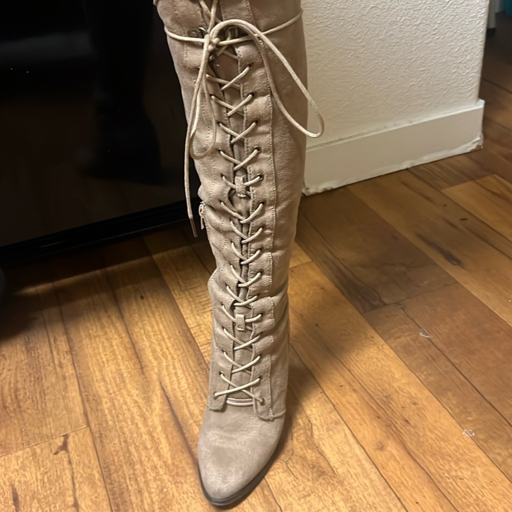 Tan knee high boots, high laced.